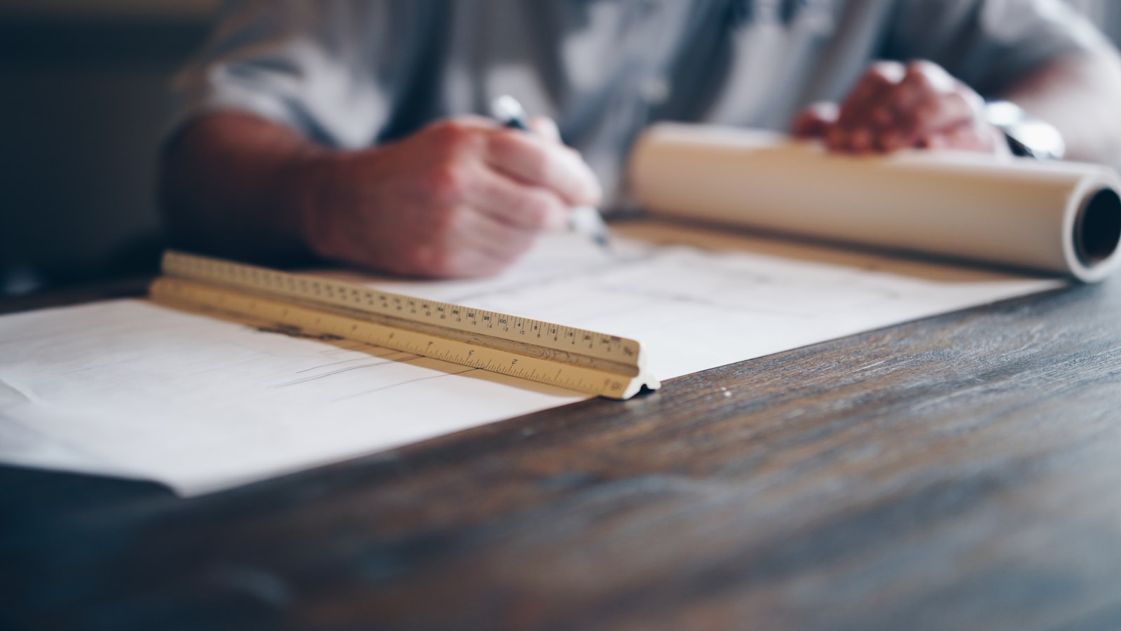 Hands drafting over an architectural blueprint